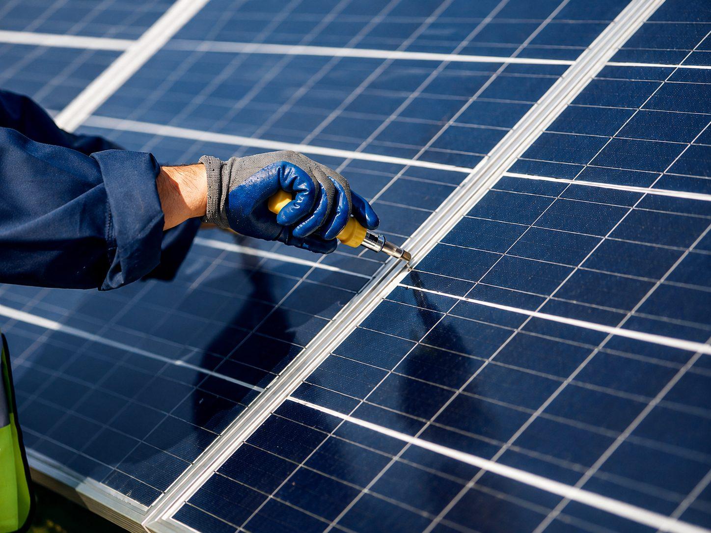 A technician fastening a solar panel in the field